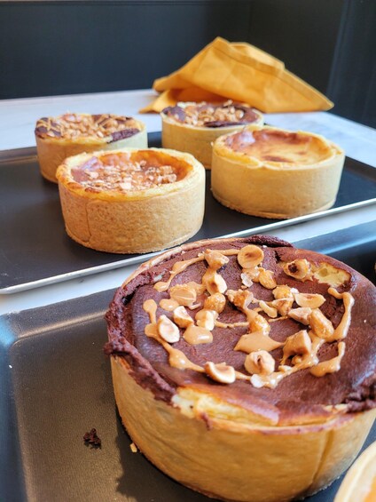 A tray of mini pies with chocolate and peanut toppings. 2