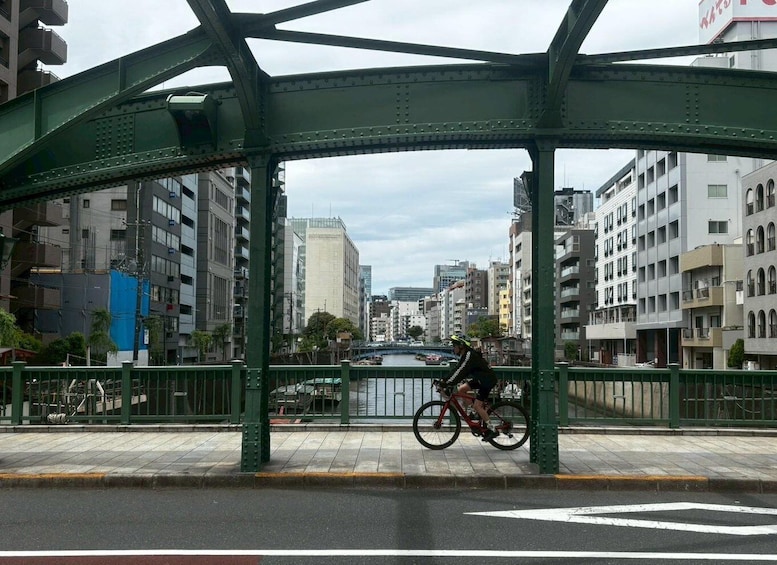 A cyclist on a bridge with a river and buildings in the background. 4