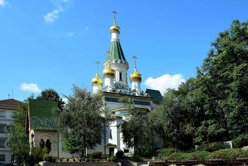A church with golden domes and a green roof. 5