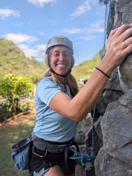 A person climbing a rock wall outdoors. 5