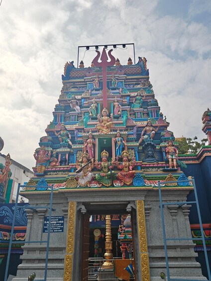 A temple with colorful statues and a central trident symbol. 3