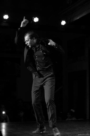 A person performing on stage with spotlights. 4