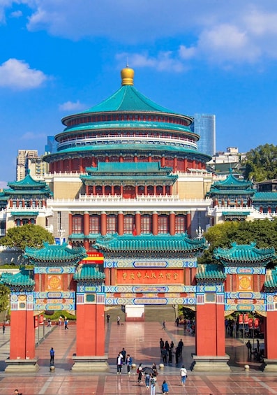 A traditional Chinese building with a green roof and red walls, surrounded by a plaza with people walking. 3