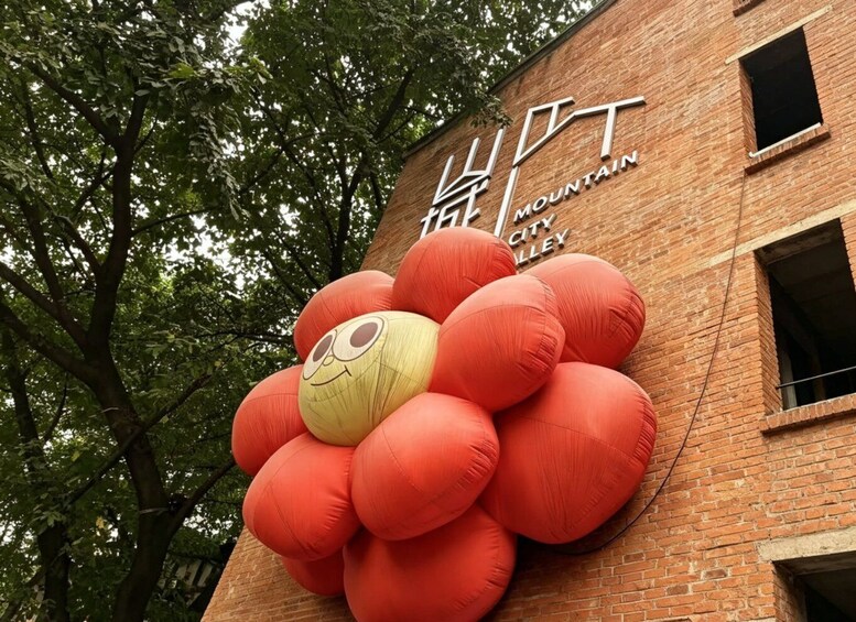 A building with a large flower sculpture and the text 'MOUNTAIN CITY VALLEY' on its facade. 4