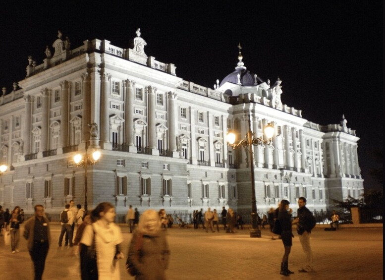 A large, ornate building with classical architecture, including columns and statues, at night. 1