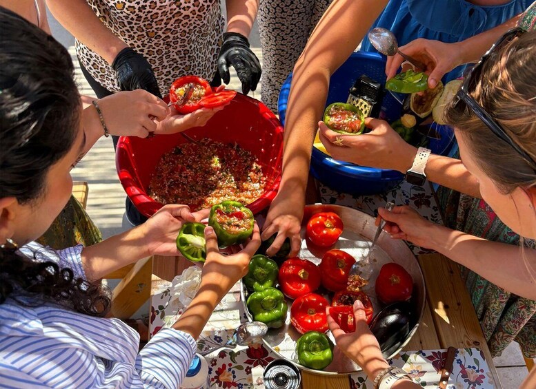 A group of people preparing stuffed bell peppers. 1