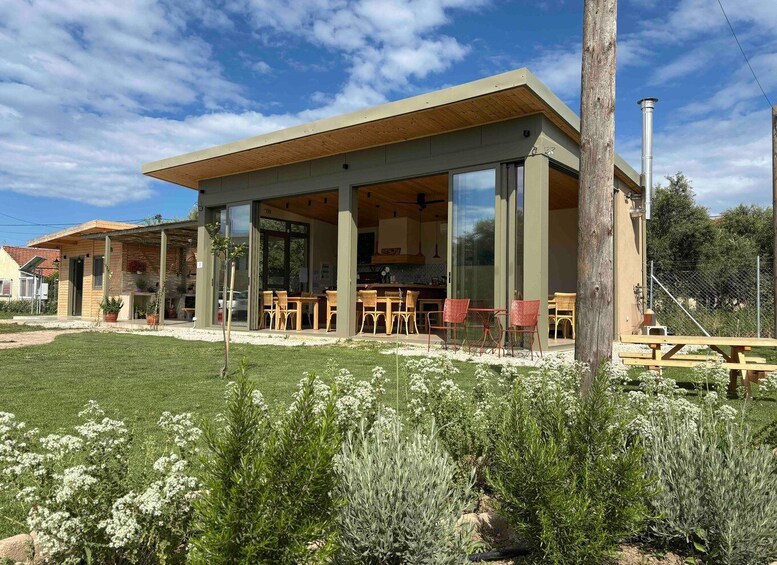A modern outdoor dining area with a covered patio, surrounded by a well-maintained garden with various plants and flowers. 3