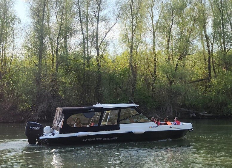 A boat named 'Corsar 900 Bowrider' on a river surrounded by trees. 1