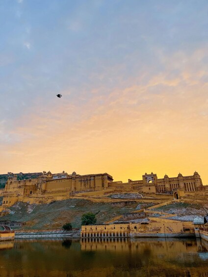 A historic fort with a moat and a flying bird in the sky. 3