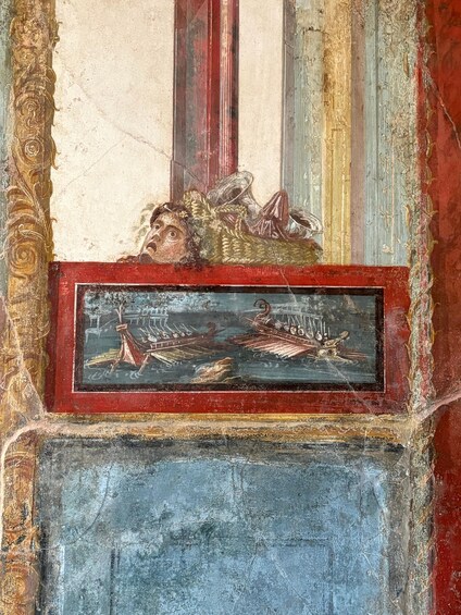 A fresco with a central figure and a framed depiction of a ship. 5