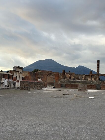 Ancient ruins with columns and a mountain in the background. 2