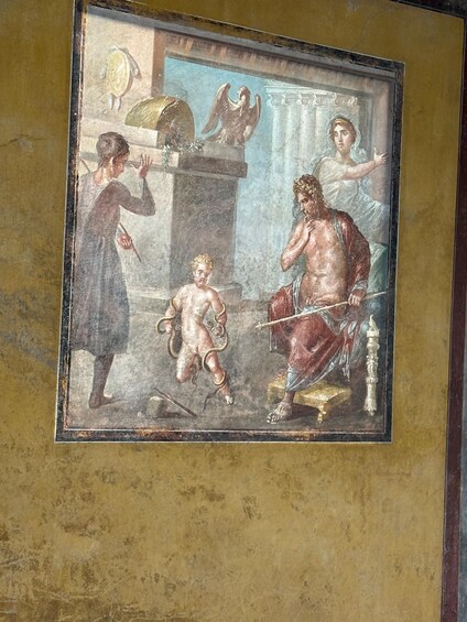 A fresco with a central figure seated on a throne, flanked by two standing figures, one holding a staff and the other a shield. 4