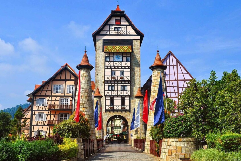 A historic building with a clock tower, multiple flags, and a cobblestone pathway. 3