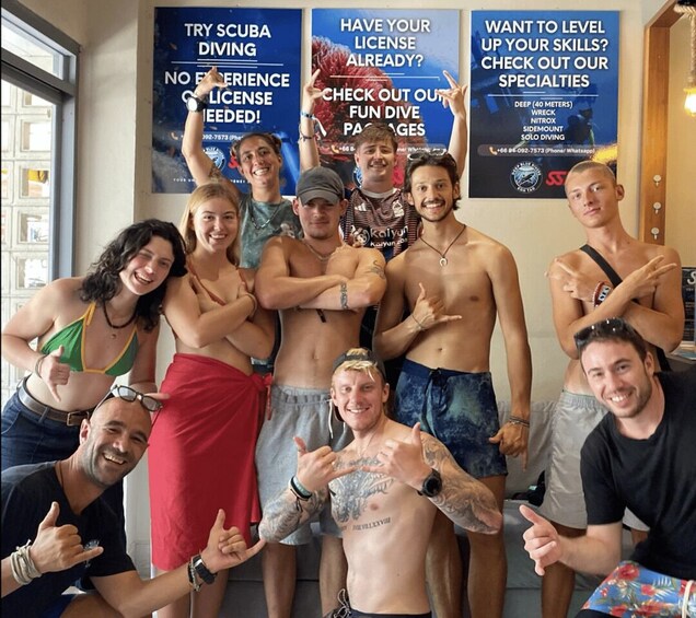A group of people in a room with posters advertising scuba diving and other water activities. 3