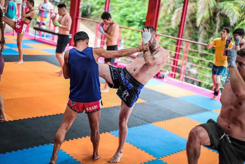 Two people practicing martial arts on a colorful mat with a red frame. 3