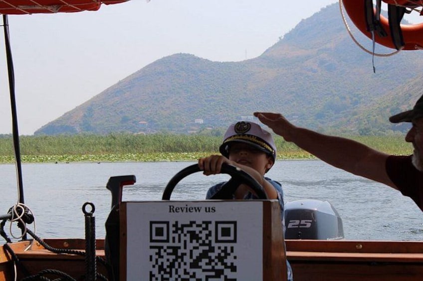 A boat with a QR code labeled 'Review us' and a person wearing a hat. 2