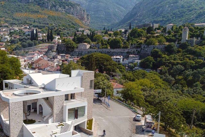 A modern building with a unique circular design, surrounded by lush greenery and a mountainous backdrop. 2