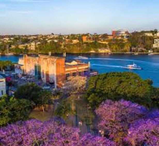 A river with boats, a building with a golden facade, and purple flowers in the foreground. 2