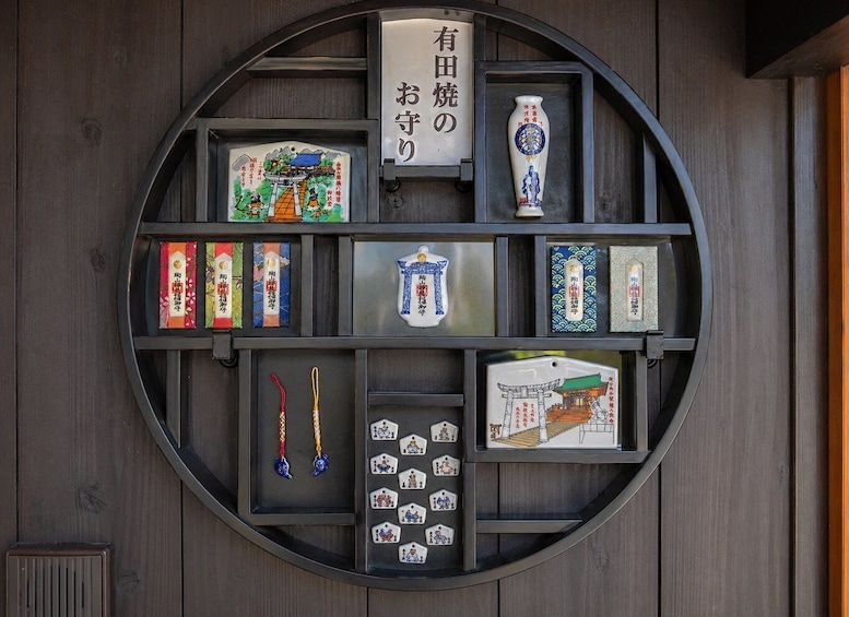A wooden wall with a circular shelf displaying various Japanese cultural items. 3