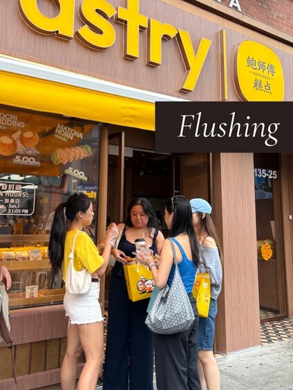 A pastry shop with a yellow awning and a sign that reads 'Flushing.' 1