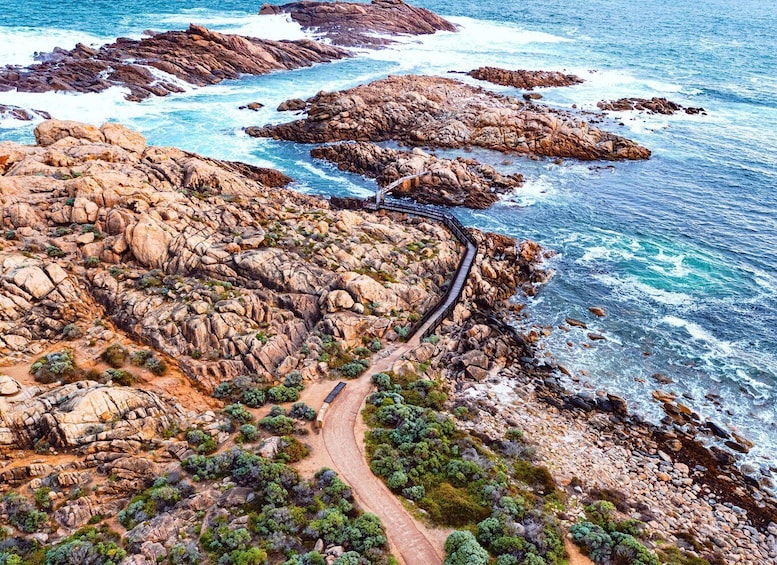 A coastal landscape with rocky terrain, a winding path, and the ocean. 3