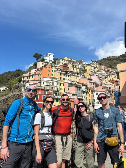 A group of people standing in front of colorful buildings on a hillside. 2
