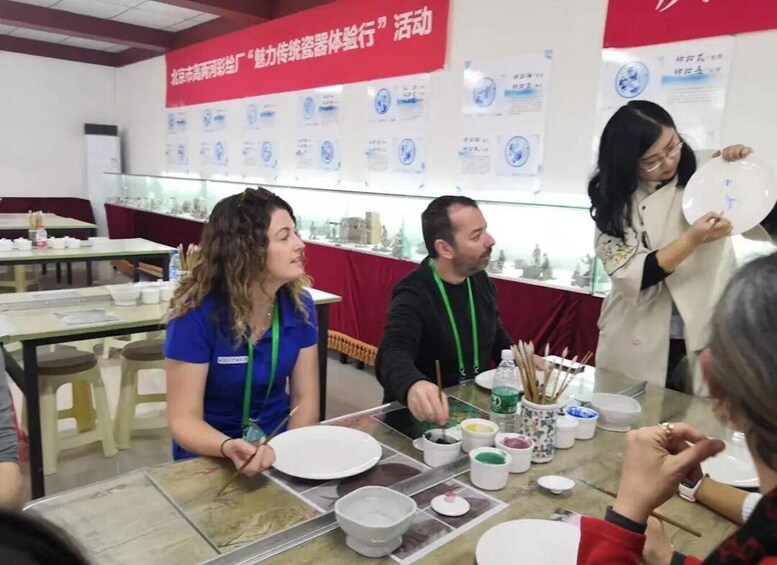 A group of people engaged in a painting activity at a table with various painting supplies. 3