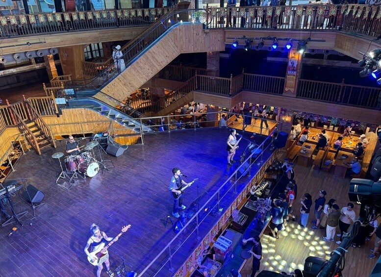 A live band performing on a stage with a crowd seated around. 3