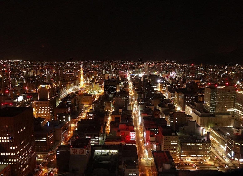 A nighttime cityscape with illuminated buildings and busy streets. 2