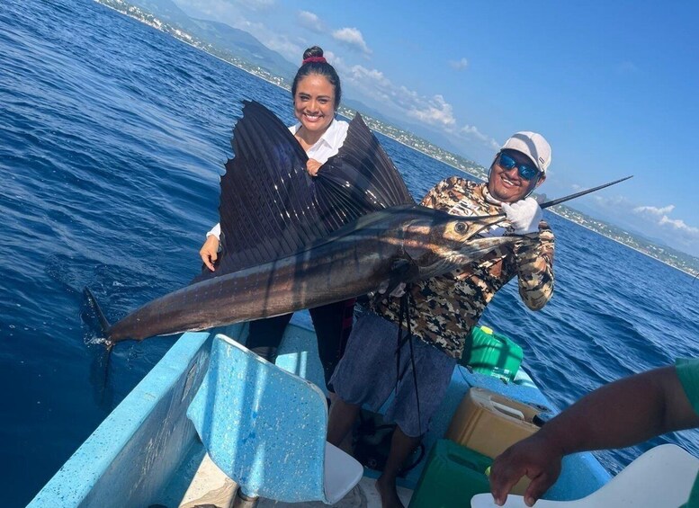 Two people on a boat holding a large fish. 2