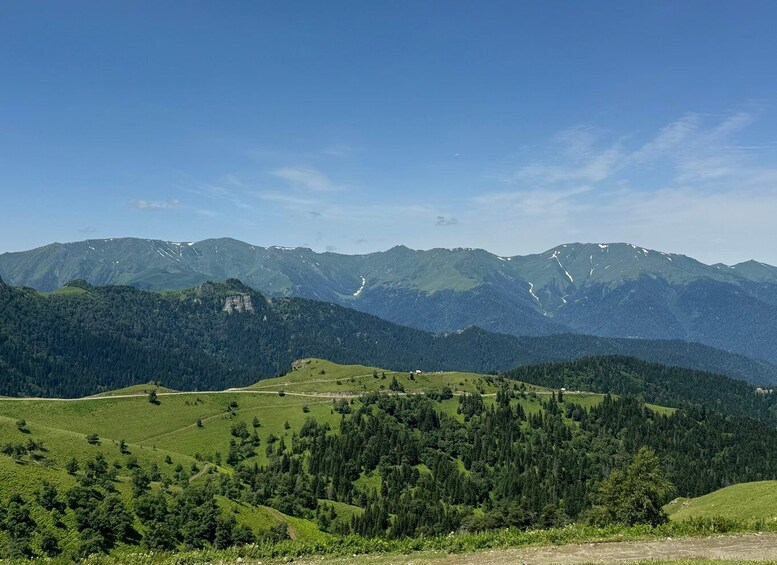 A mountainous landscape with green valleys and a clear sky. 1