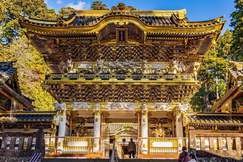 A traditional Japanese temple with ornate golden decorations and statues. 2