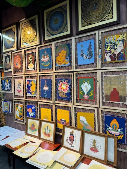 A wall of framed artwork with various traditional and cultural designs. 1