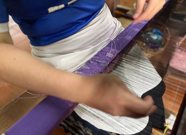 A person weaving with a loom. 2