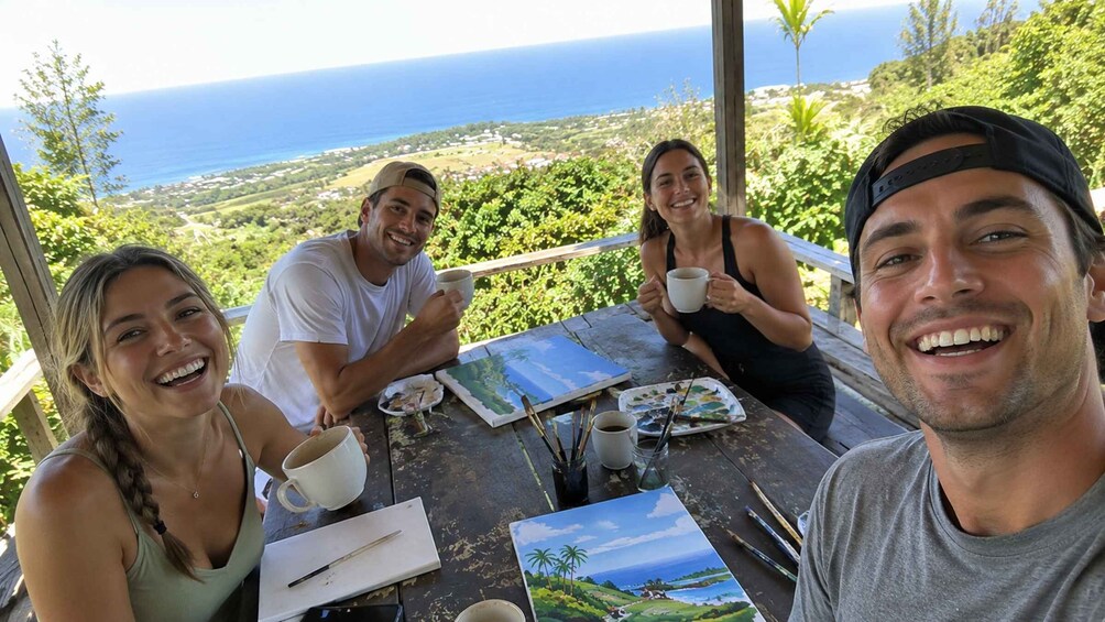 Three people painting at a table with a scenic ocean view in the background. 1