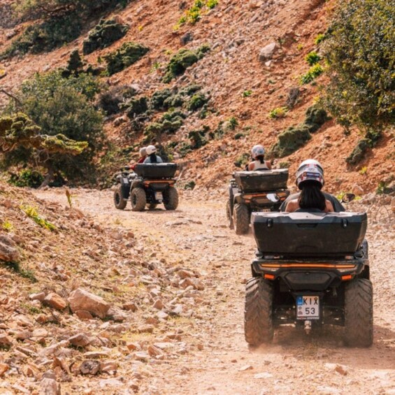 Three off-road vehicles on a rocky trail with sparse vegetation. 3