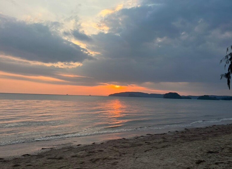 A beach at sunset with calm waters reflecting the sky. 4