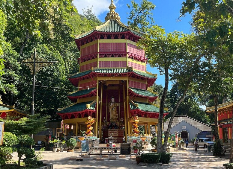 A multi-tiered pagoda with a golden roof, surrounded by lush greenery and traditional architecture. 2