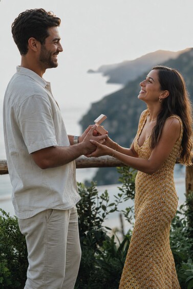 A couple outdoors, a man holding a ring, and a woman wearing a yellow dress. 1