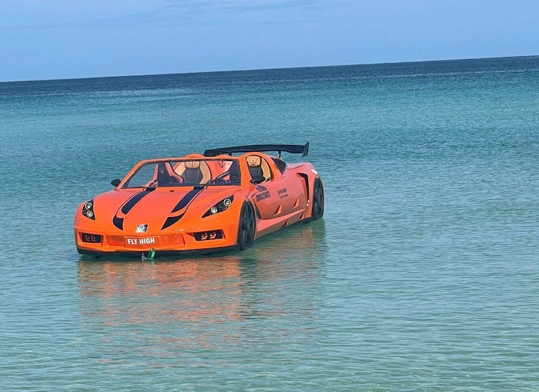 An orange sports car partially submerged in calm ocean waters. 2