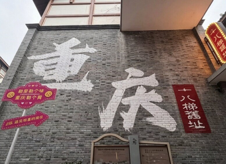 A brick building with large white Chinese characters and a red sign with white text. 1