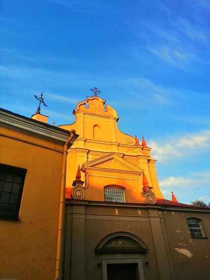 A church with a bell tower and a weather vane, under a clear sky. 5