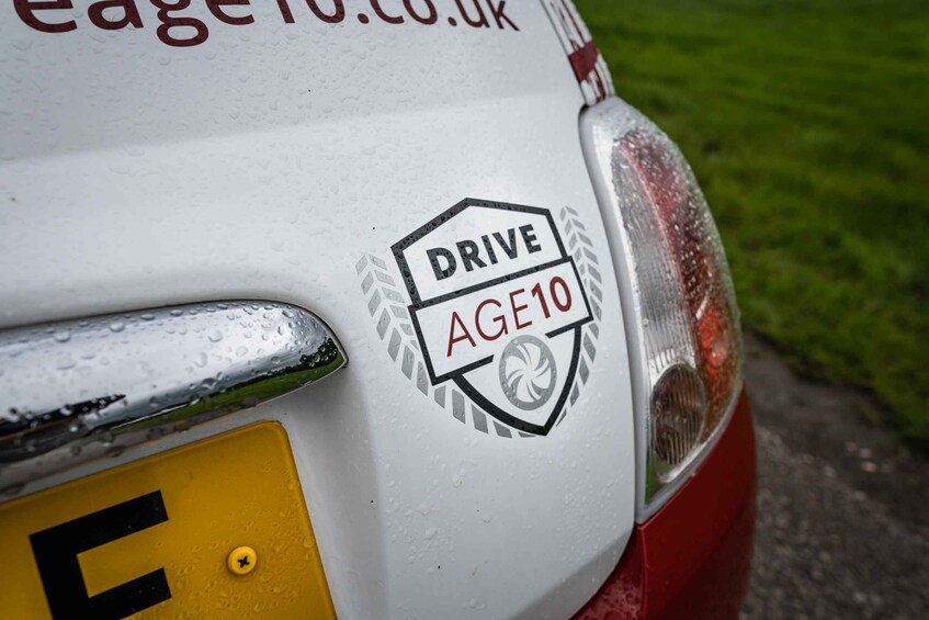 A vehicle with a 'DRIVE AGE10' badge and a yellow license plate. 2