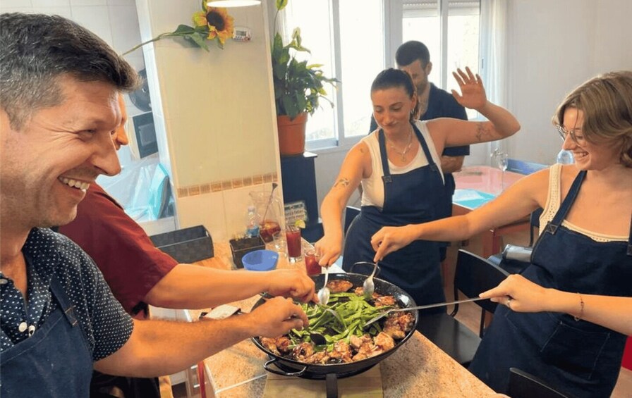 A group of people cooking together in a kitchen. 2
