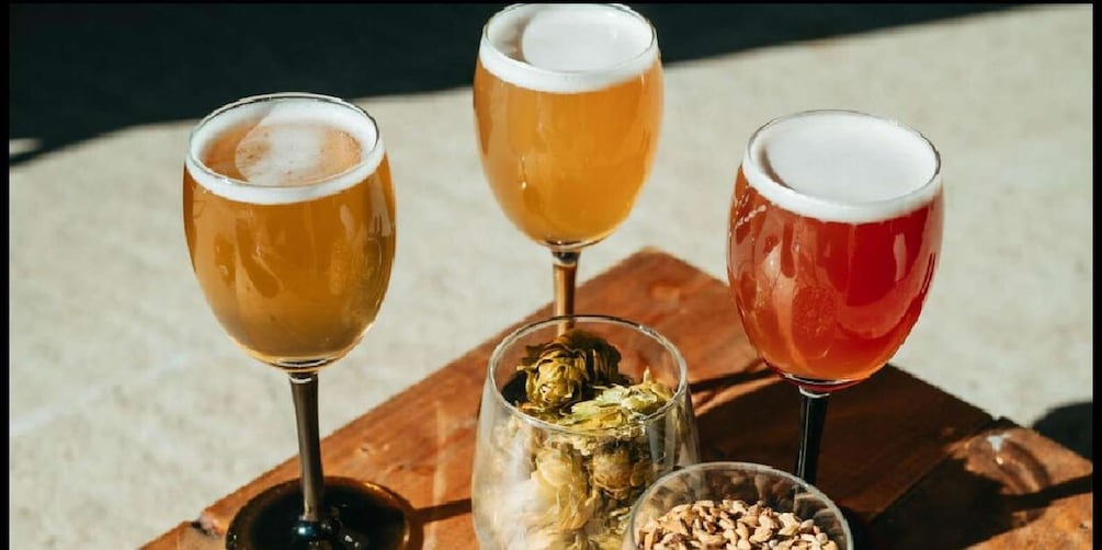 Three glasses of beer on a wooden board. 1