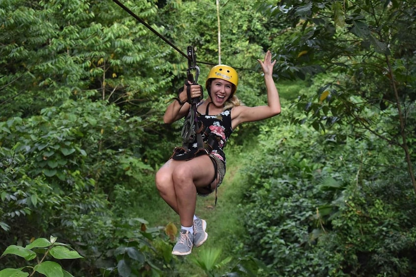 A person zip-lining through a dense forest. 1