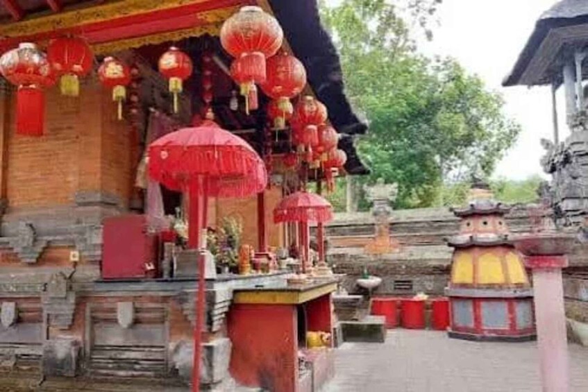 A traditional temple with red lanterns, a stone altar, and a stone pathway. 3