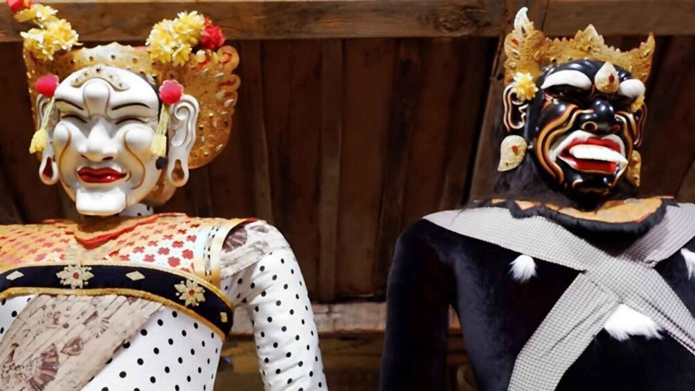 Two individuals in traditional attire with elaborate headpieces and masks. 5