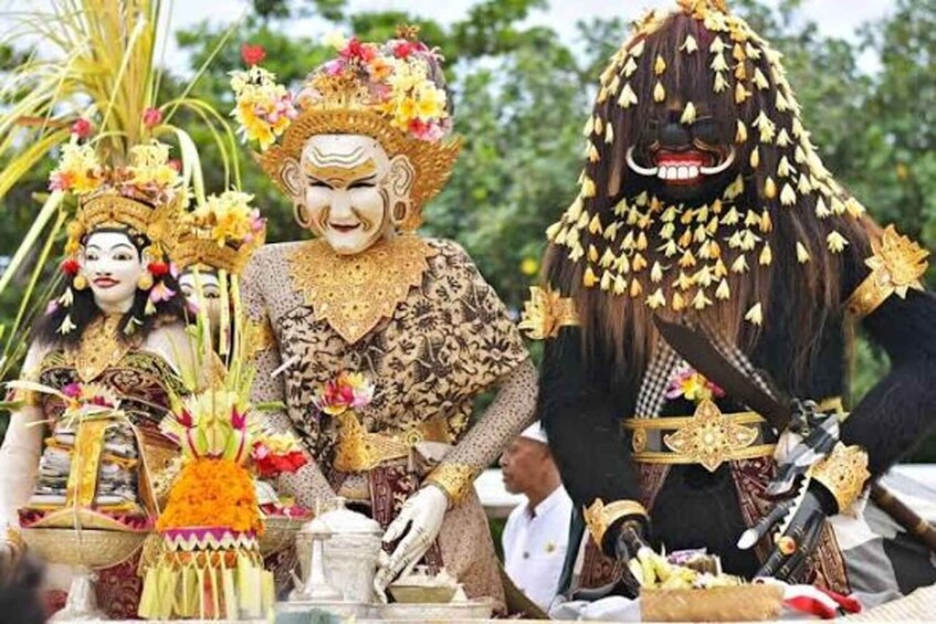 A person in elaborate traditional attire with a headdress and a mask, surrounded by ceremonial objects. 2