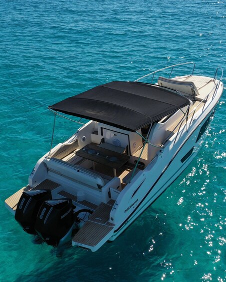 A white motorboat with a black canopy, two Mercury outboard motors, and a 'Paradise' label on the side. 4